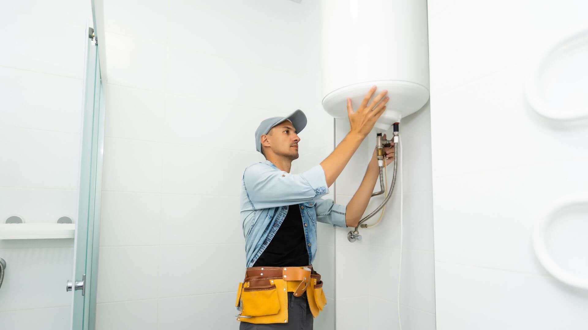 A plumber or technician inspecting a hot water system in a rental property, representing the importance of landlord insurance for unexpected maintenance issues.