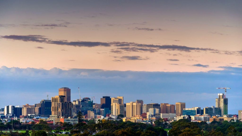Adelaide city skyline at sunset, symbolising building wealth through property and long-term investment opportunities.